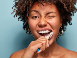 mulher negra escovando os dentes